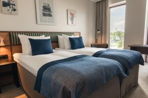 ein Hotelzimmer mit zwei Betten und einem Fenster in der Unterkunft Quality Hotel The Book in Göteborg