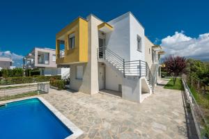 a villa with a swimming pool and a house at SLV Danai 7 Apartments in Ofrínion