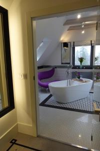 a bathroom with a large tub and a sink at NovaWisła Resort & SPA in Wisła +65 photos