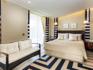 a bedroom with a bed and a couch at Rixos Premium Göcek - Adult Only in Göcek