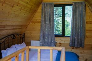 a bedroom with a bed in a log cabin at Kokhta Cottage Kazbegi 2 in Kazbegi