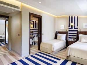 a hotel room with two beds and a bathroom at Rixos Premium Göcek - Adult Only in Göcek +174 photos