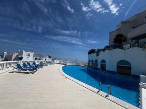 a swimming pool on the side of a building with chairs at Perlazul in Peniscola