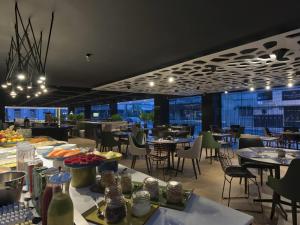 a restaurant with tables and chairs with a view at Novotel Itajai Navegantes in Itajaí