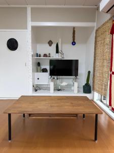 a living room with a coffee table and a flat screen tv at MIYARA GARDEN House in Ishigaki Island