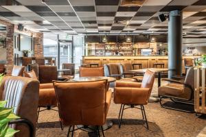 a restaurant with tables and chairs and a bar at Scandic Waskia in Vaasa