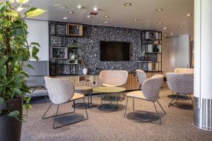 a meeting room with chairs and a table and a tv at Scandic Waskia in Vaasa