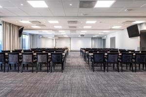 a conference room with tables and chairs and a screen at Scandic Waskia in Vaasa