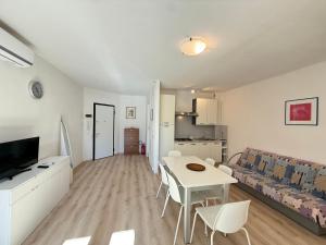a white living room with a table and a couch at Residence Luna in Lignano Sabbiadoro