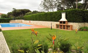 a garden with a swimming pool and a house at D. Duarte Townhouse in Casal da Lagoa Seca