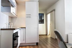 a kitchen with white cabinets and a refrigerator at One-bedroom apt with balcony on Rue Hoche in Cannes