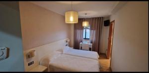 a bedroom with two white beds in a room at Casa Savi in Miño