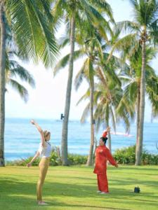 two women are playing frisbee on the beach at Sheraton Sanya Yalong Bay Resort in Sanya