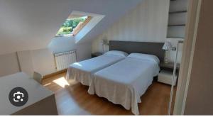 a bedroom with two beds and a window at Casa Savi in Miño