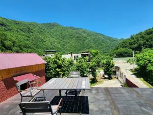 a picnic table and chairs on the roof of a building at Teo's cottage in Maradidi