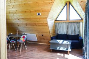 a living room with a blue couch and a table at Kokhta Cottage Kazbegi 2 in Kazbegi