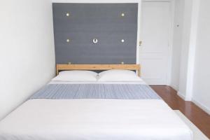 a bedroom with a white bed with a blue wall at Colombo Mall Room in Lisbon