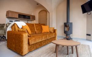 a living room with a brown couch and a table at Riverberg puhkemaja Otepääl in Otepää