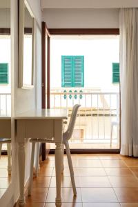a table and a chair in a room with a balcony at Hostal Cala Ratjada in Cala Ratjada