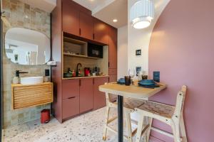 a small kitchen with a wooden table and chairs at Suite romantique Ibiza, Jacuzzi, Spa in Strasbourg