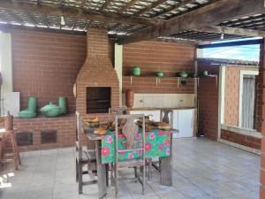 a kitchen with a table and a brick wall at Flat Alto Padrão in Gravatá
