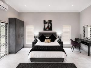 a bedroom with a large bed and a desk at Ridgeworth Royale in Tyger Valley