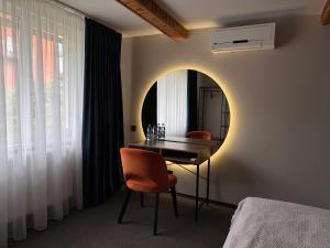a room with a mirror and a table and chairs at Котедж Gudz in Yaremche
