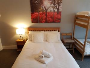 1 dormitorio con 1 cama con toallas en The Craigside en Skegness