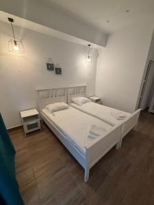 a bedroom with a white bed and two night stands at Casa Maria in Vama Veche
