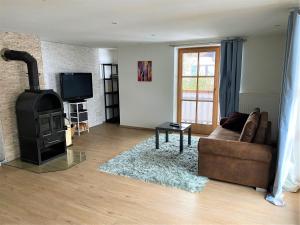 a living room with a couch and a wood stove at Ferienwohnung Am Mühlbach 1 in Halblech