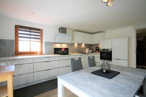 a kitchen with white cabinets and a table with chairs at Ferienwohnung Am Mühlbach 1 in Halblech +11 photos