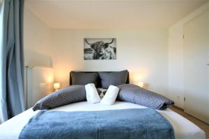 a bedroom with a bed with a bull picture on the wall at Ferienwohnung Am Mühlbach 1 in Halblech