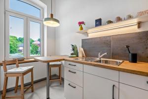 a kitchen with white cabinets and a sink and a window at Ferienwohnung auf Dreiseithof in Twedt