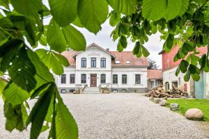 a large white house with a large driveway at Ferienwohnung auf Dreiseithof in Twedt