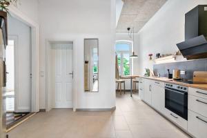 a white kitchen with white appliances and a table at Ferienwohnung auf Dreiseithof in Twedt +17 photos