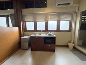 a small kitchen with a sink and a dishwasher at Sukstay Hotel in Bangkok