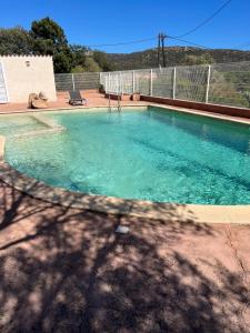 a swimming pool with blue water in a yard at Residence La Beloutiere in Porto-Vecchio