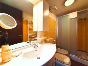a bathroom with a sink and a toilet and a mirror at DIMORA Concept - Yellow Apartment in Ceriale