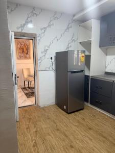 a kitchen with a refrigerator in the middle of a room at Pristine Residences Premium 2 Bedroom Apartment Ajah Lagos in Lekki