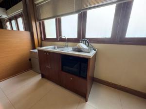 a kitchen with a sink and two windows at Sukstay Hotel in Bangkok