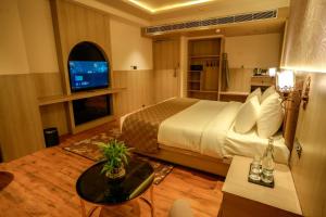 a hotel room with a bed and a television at Barsana Hotel & Resorts in Jaipur