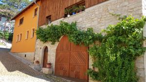 a building with a wooden garage door and vines at Ferienwohnung Giesa in Jena