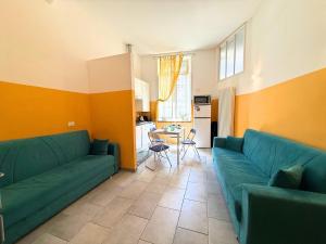 a living room with a green couch and a table at DIMORA Concept - Yellow Apartment in Ceriale