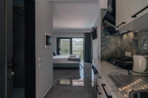 a kitchen with a view of a room with a bed at Irida Studios and Suite in Paleokastritsa