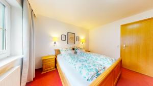 a bedroom with a bed with a blue and white comforter at Wohnhaus Christoph in Längenfeld