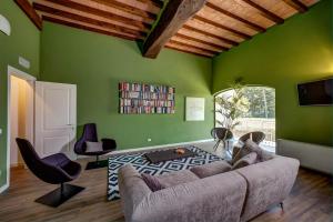 サーラ・バガンツァにあるHotel Cortaccia Sanvitaleの緑の壁のリビングルーム(ソファ、椅子付)