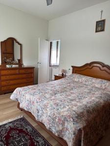 a bedroom with a bed and a dresser and a mirror at Casa di Nonni in I Forti
