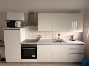a white kitchen with a sink and a microwave at Apartment Ivan in Karlobag