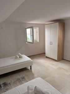 a white room with a bed and a cabinet at Apartment Ivan in Karlobag