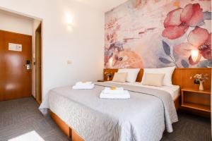 a hotel room with two beds and a painting on the wall at Hotel Kastil in Bol